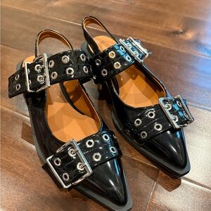 Black sling back flats with silver buckle and grommet detail. Size 38. Like new